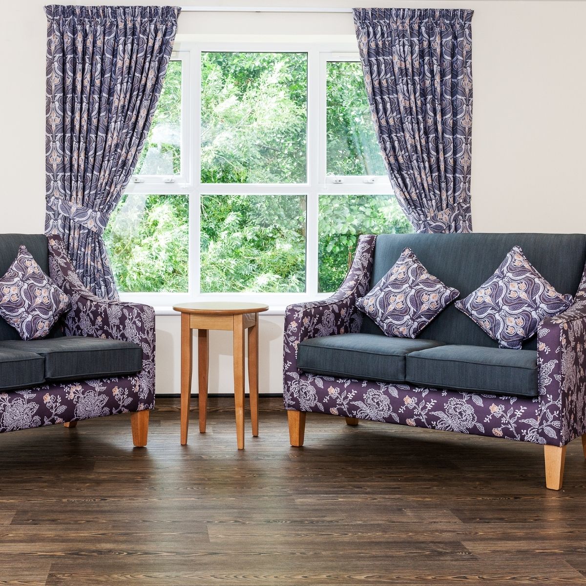 lounge room in care home with two sofas and a coffee table around a window
